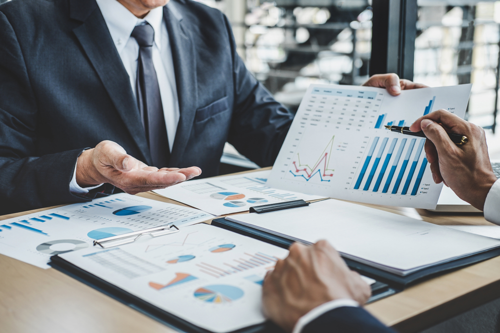 A man in a suit reviewing financial charts
